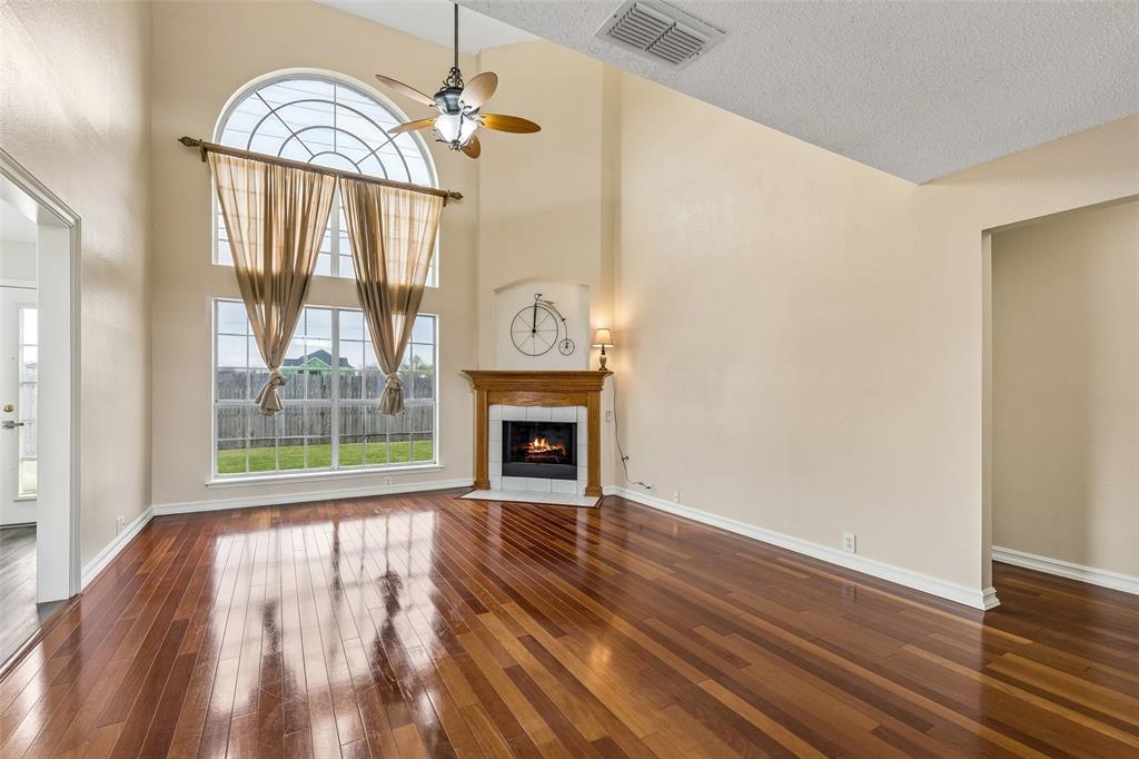 133 Hanover Street Grand Prairie, TX 75052 - Photo 5 of 31 a view of an empty room with wooden floor fireplace and a window