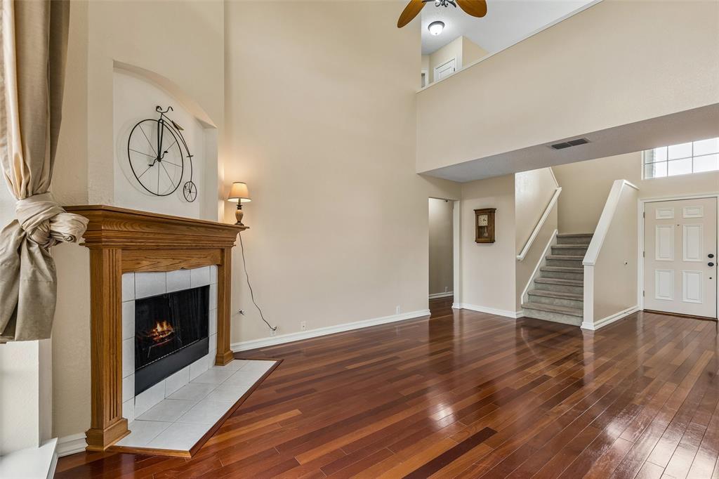 133 Hanover Street Grand Prairie, TX 75052 - Photo 7 of 31 a view of an empty room with wooden floor fireplace and a window