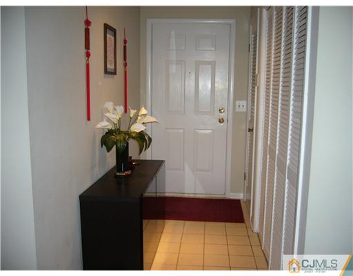 116 Heather Court Edison, NJ 08820 - Photo 2 of 9 a vase of flowers sitting on a floor in front of a window