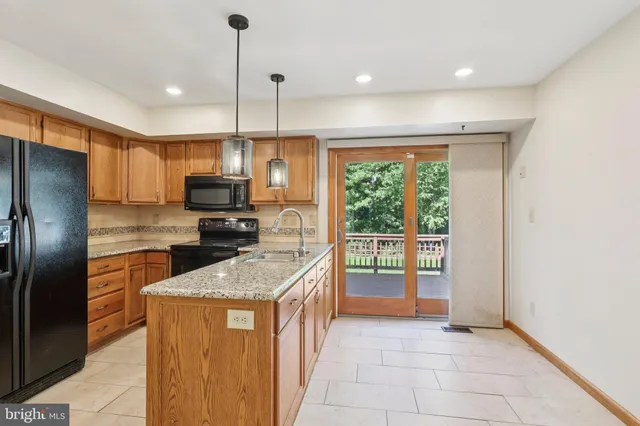 a kitchen with stainless steel appliances granite countertop a refrigerator a sink a stove and oven