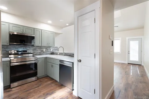 a kitchen with stainless steel appliances white cabinets and a stove top oven