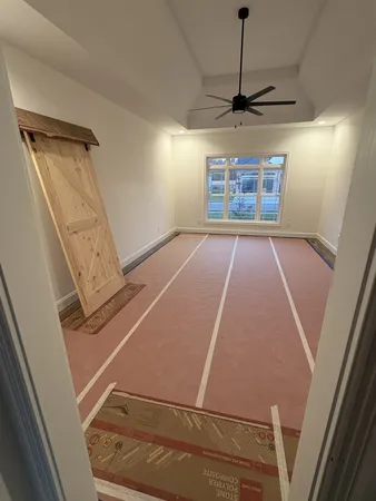 a living room with stainless steel appliances lots of white furniture a rug and a projector