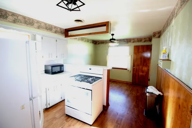 a kitchen with a refrigerator and a stove top oven