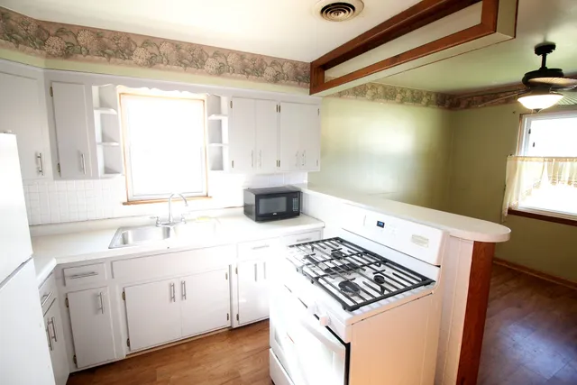 a kitchen with a stove a sink and a window