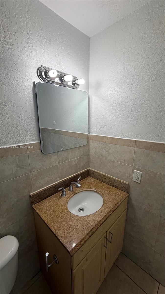 3901 Southwest 109th Avenue, Unit 4 Miami, FL 33165 - Photo 11 of 15 a bathroom with a granite countertop sink and a mirror