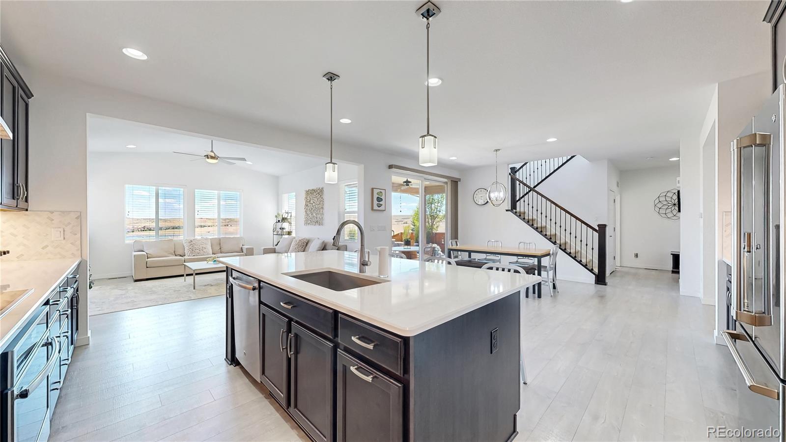 13950 Box Turtle Loop Parker, CO 80134 - Photo 11 of 48 a kitchen with a sink a stove a refrigerator and wooden floor