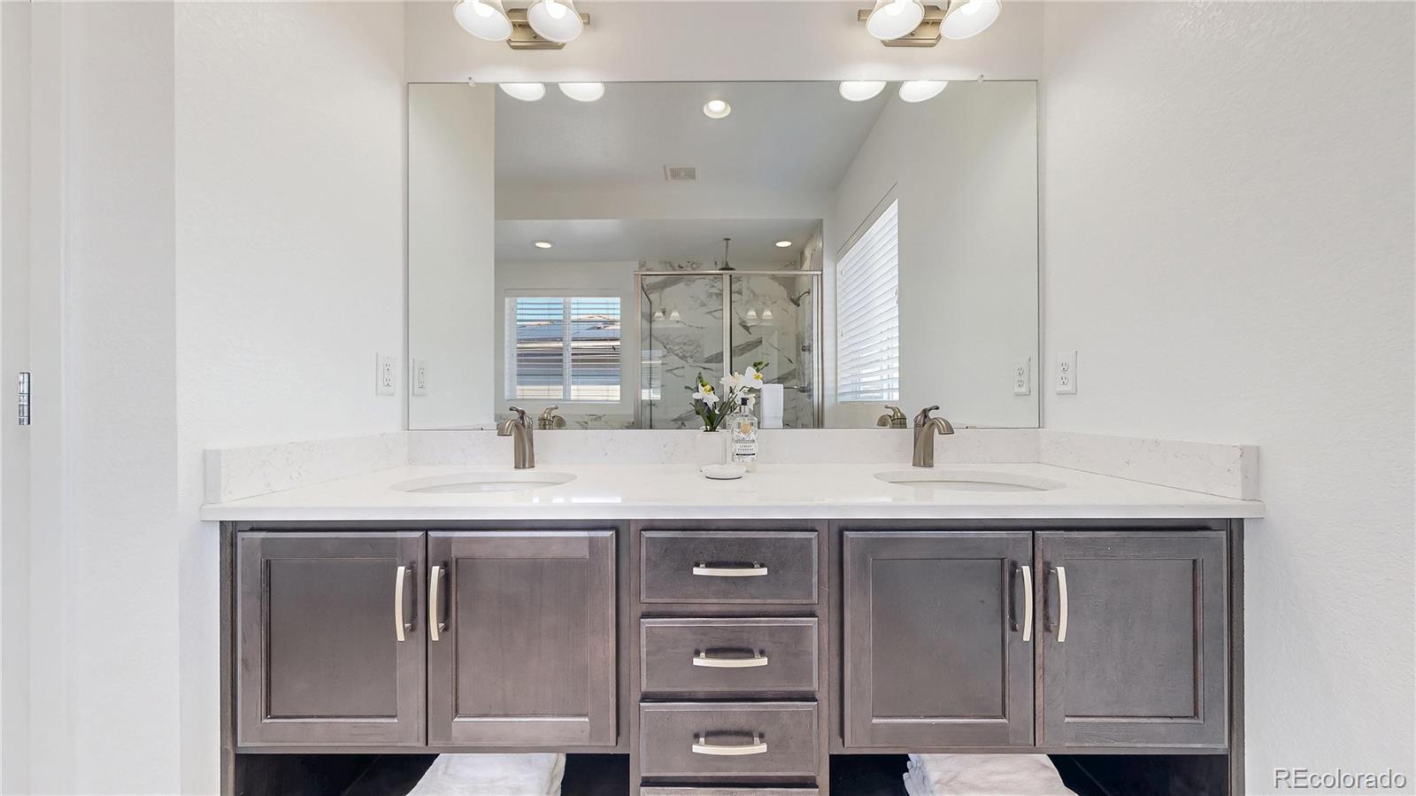 13950 Box Turtle Loop Parker, CO 80134 - Photo 18 of 48 a bathroom with a granite countertop sink a toilet and a mirror