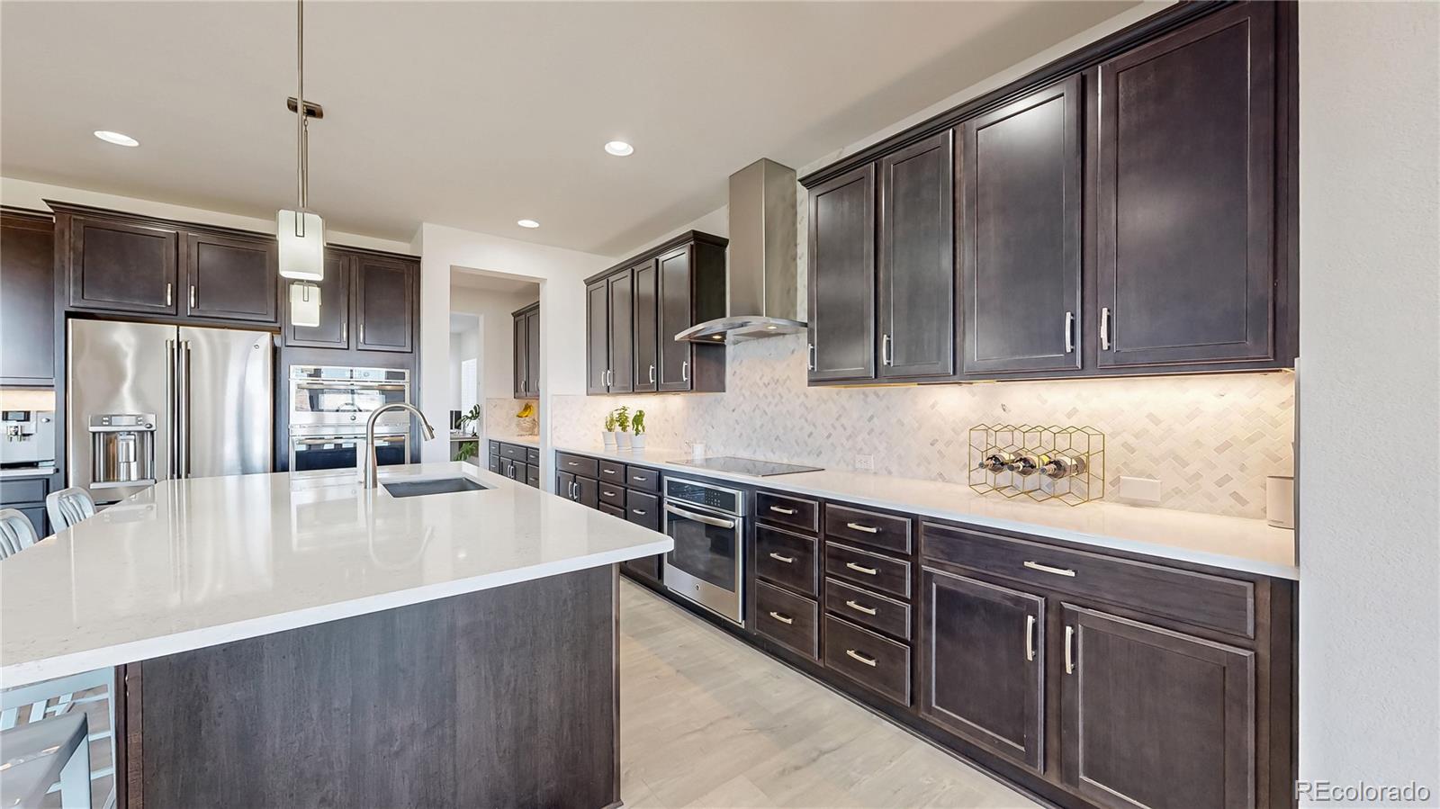 13950 Box Turtle Loop Parker, CO 80134 - Photo 8 of 48 a large kitchen with stainless steel appliances granite countertop a refrigerator a sink and a stove