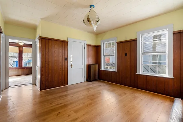 a view of empty room with wooden floor and windows