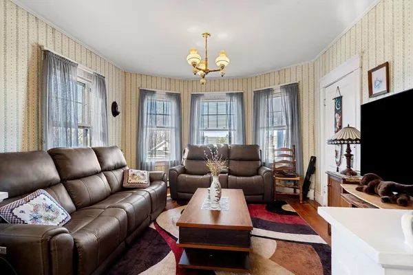 a living room with furniture a flat screen tv and a window