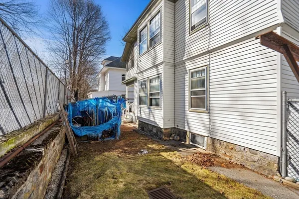 a view of a chair and fire pit in the back yard of the house