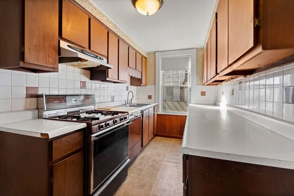 a kitchen with stainless steel appliances granite countertop a stove a sink and a microwave