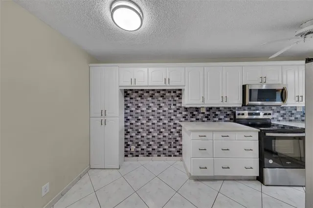 a kitchen with white cabinets and appliances