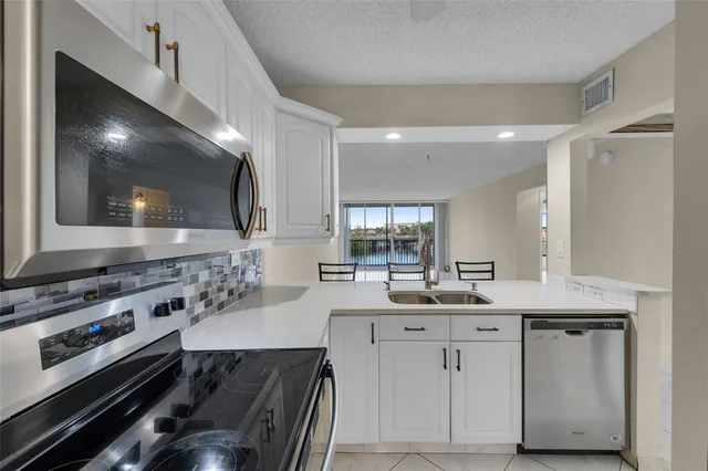 a kitchen with a sink appliances and cabinets