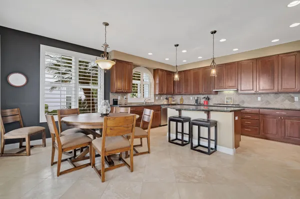 a kitchen with stainless steel appliances granite countertop a kitchen island a stove and a sink