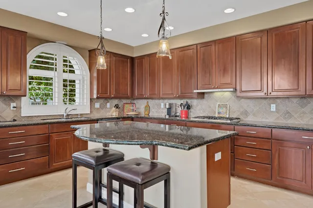 a kitchen with stainless steel appliances granite countertop a stove a sink and a refrigerator