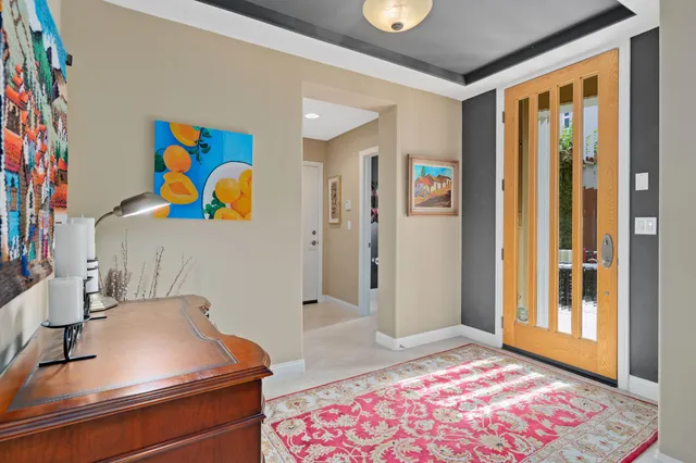 a living room with furniture floor to ceiling window and a flat screen tv