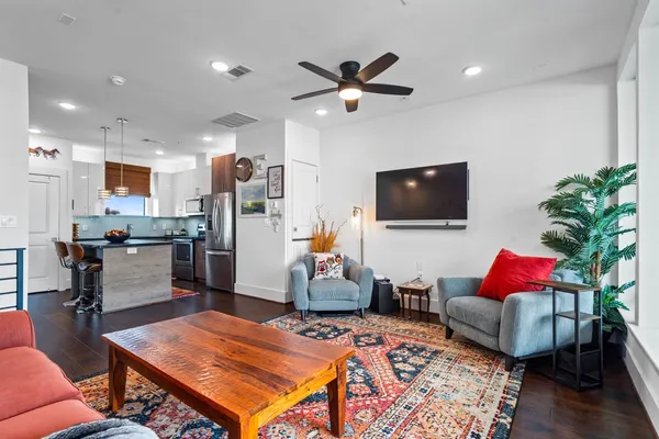 a kitchen with stainless steel appliances granite countertop a sink dishwasher a dining table and chairs with wooden floor