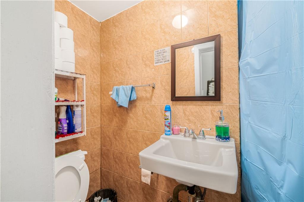 142 Neptune Avenue Brooklyn, NY 11235 - Photo 13 of 17 a bathroom with a sink a toilet and mirror