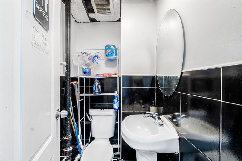 142 Neptune Avenue Brooklyn, NY 11235 - Photo 16 of 17 a bathroom with a sink a toilet and shower