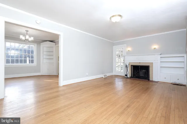 wooden floor fireplace and windows in an empty room