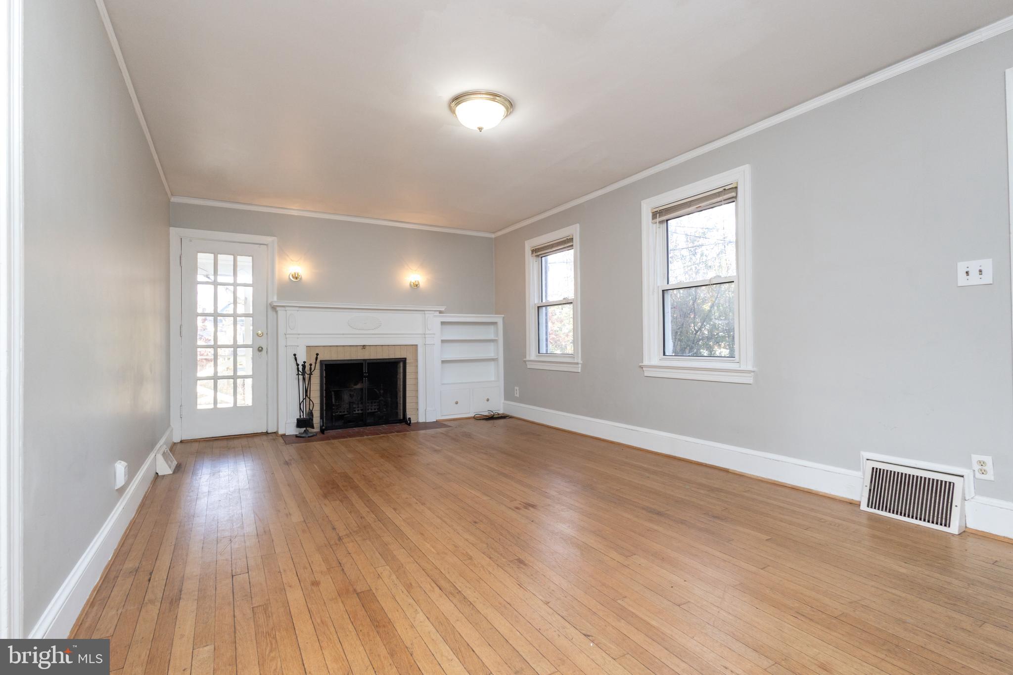 312 North Highland Street Arlington, VA 22201 - Photo 8 of 33 an empty room with wooden floor fireplace and windows