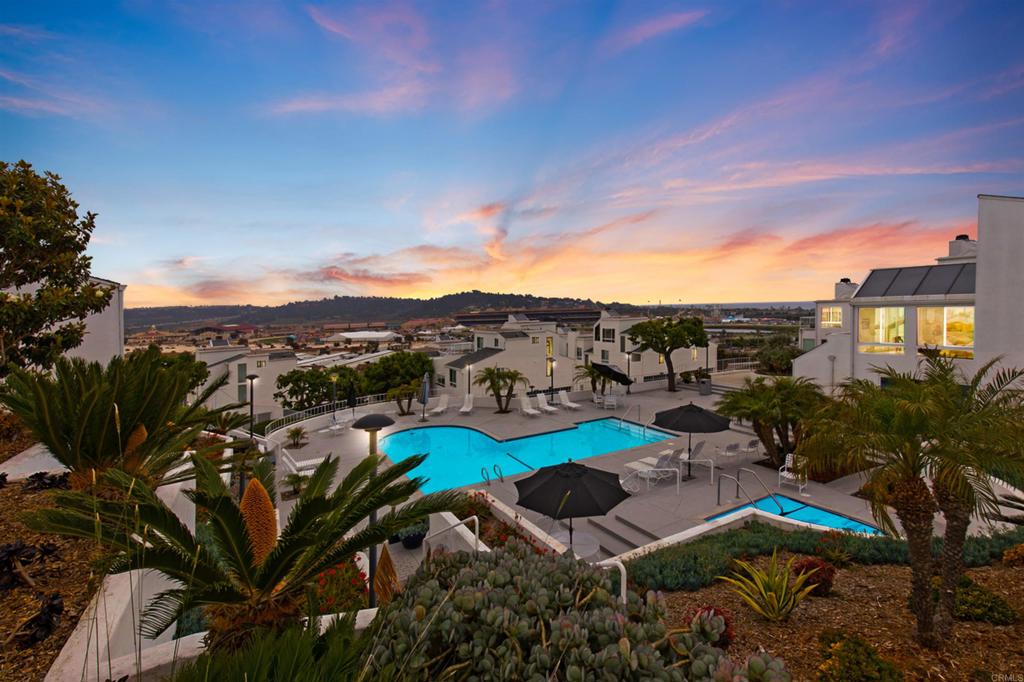 a view of a city with lawn chairs under an umbrella