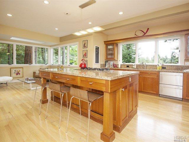 a dining hall with stainless steel appliances granite countertop a stove top oven a sink with dining table and chairs