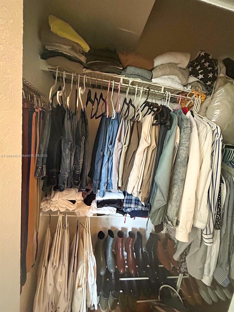 7635 Southampton Terrace, Unit 201 Tamarac, FL 33321 - Photo 21 of 23 a view of walk in closet with clothes and shoes