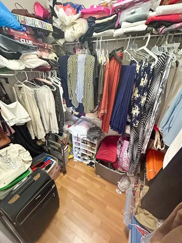 a view of walk in closet with clothes and shoes