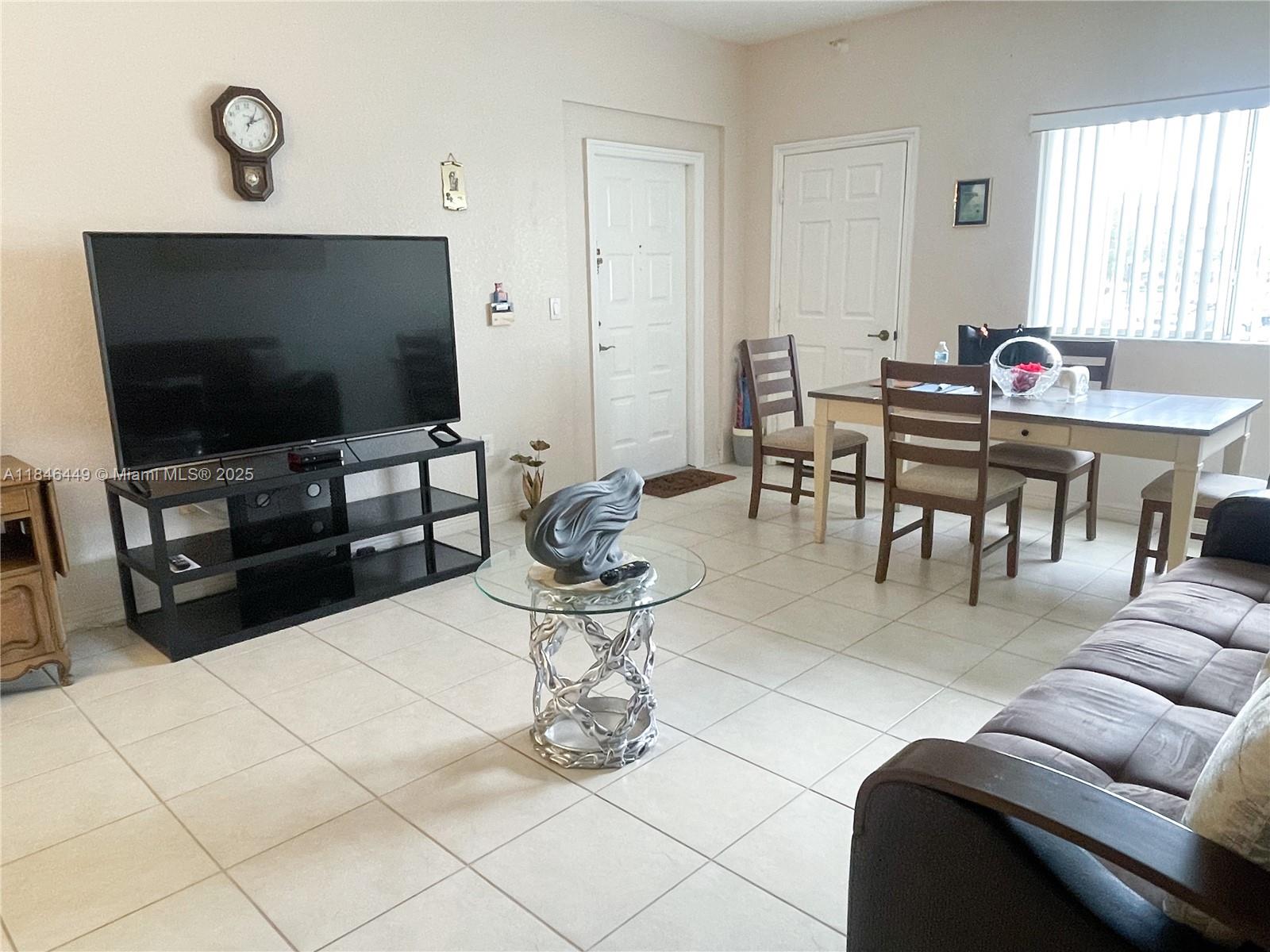7635 Southampton Terrace, Unit 201 Tamarac, FL 33321 - Photo 3 of 23 a living room with furniture and a flat screen tv