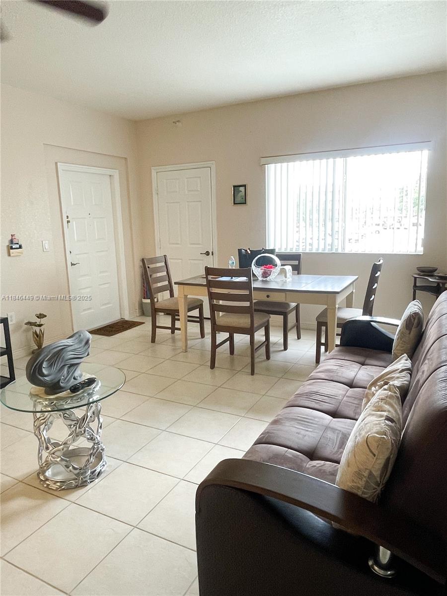 7635 Southampton Terrace, Unit 201 Tamarac, FL 33321 - Photo 4 of 23 a living room with furniture a table and a window