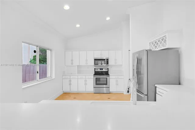 a kitchen with stainless steel appliances a refrigerator and a stove top oven