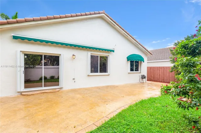 a view of a house with backyard and tree