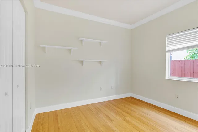 a view of empty room with wooden floor