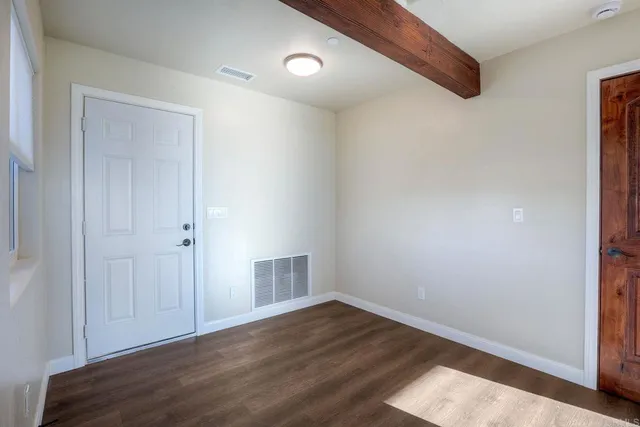 a view of an empty room with wooden floor
