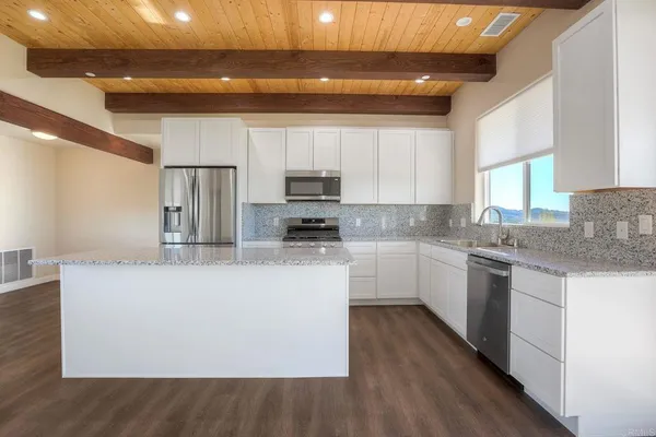 a kitchen with stainless steel appliances granite countertop a stove a sink and a refrigerator