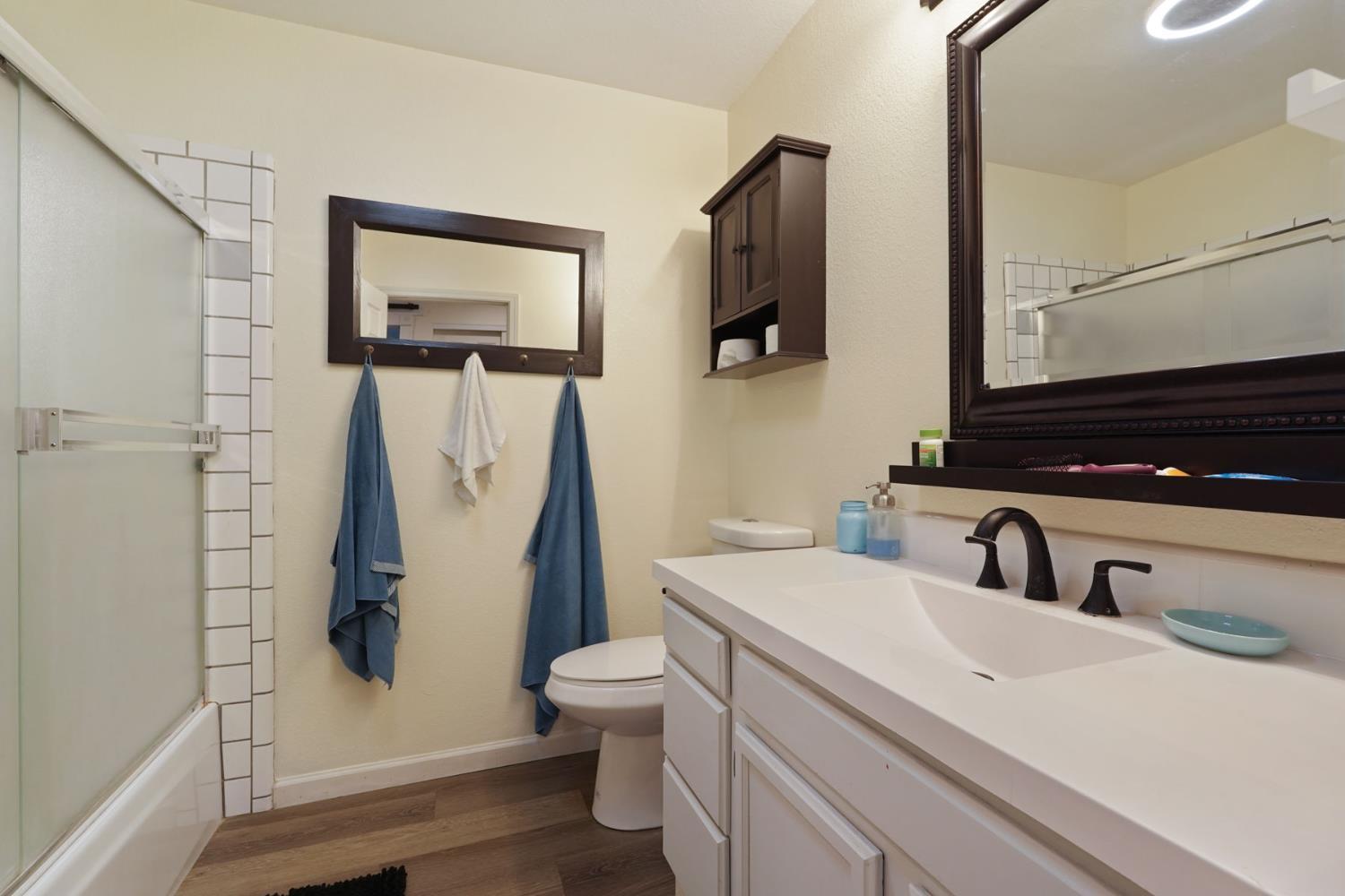 242 3rd Street Galt, CA 95632 - Photo 11 of 31 a bathroom with a sink a toilet a mirror and shower