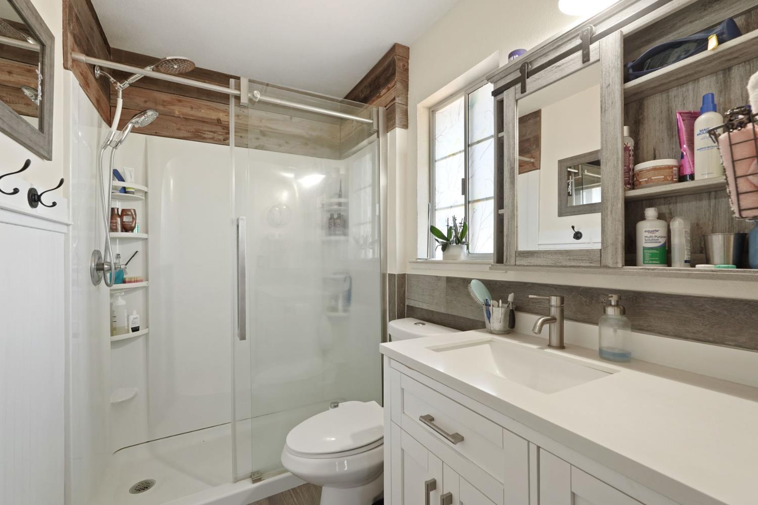 242 3rd Street Galt, CA 95632 - Photo 24 of 31 a bathroom with a shower sink vanity mirror and toilet