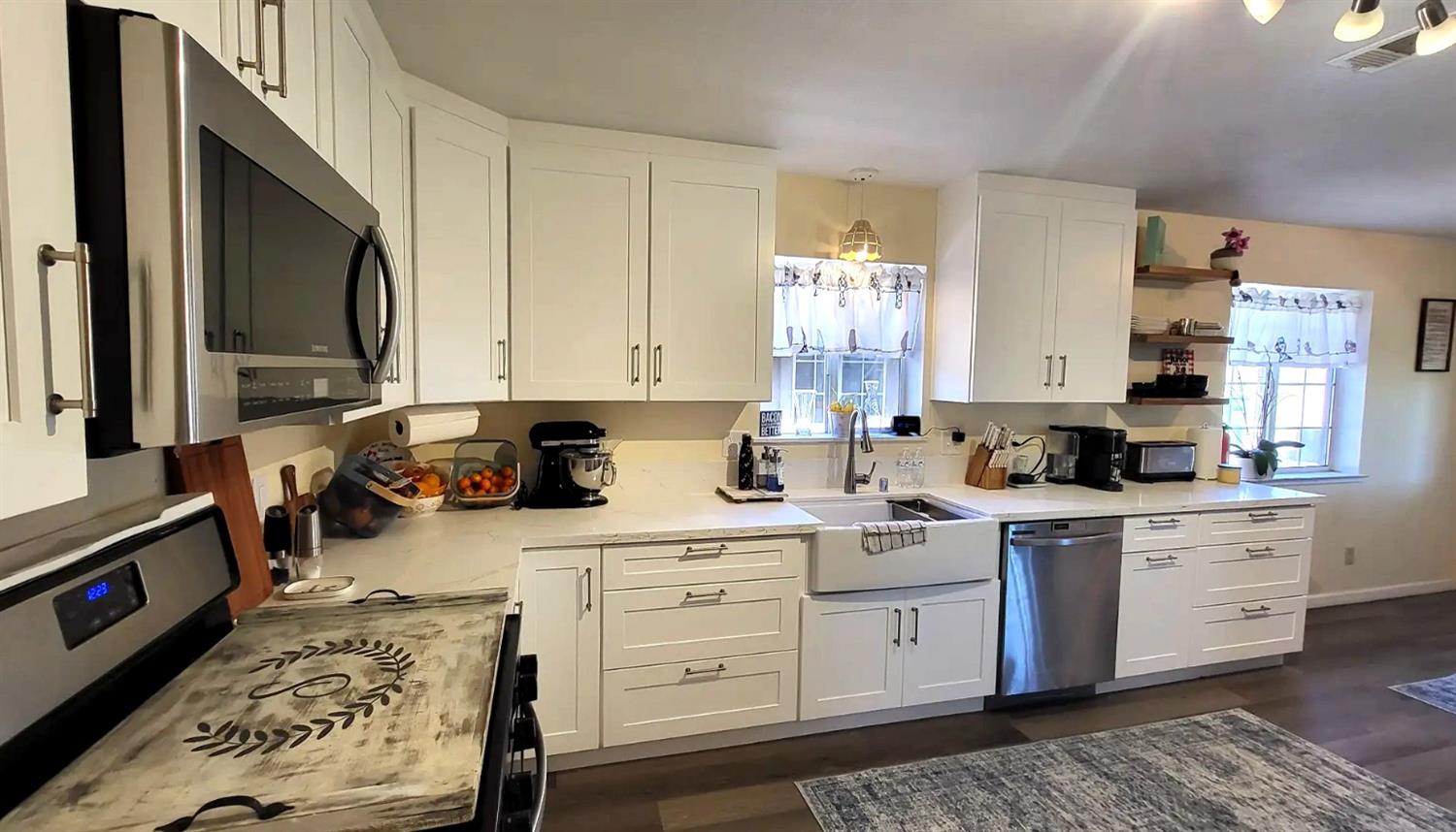 242 3rd Street Galt, CA 95632 - Photo 7 of 31 a kitchen with stainless steel appliances white cabinets sink and stove top oven