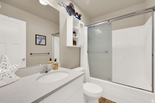 1857 Thunder Gulch Road Eagle Mountain, UT 84005 - Photo 25 of 50 Bathroom featuring a white vanity with an undermount sink and a light-toned countertop, a toilet, and a white shower-over-tub combination with a sliding glass door