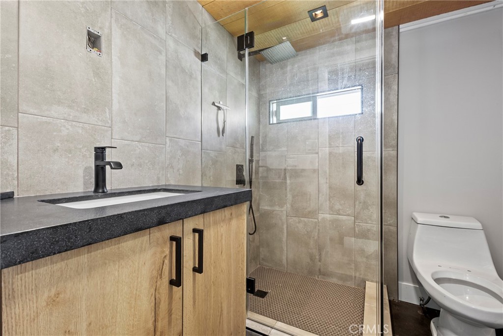 12149 Indiana Avenue, Unit 18 Riverside, CA 92503 - Photo 8 of 12 a bathroom with a granite countertop sink a toilet and shower