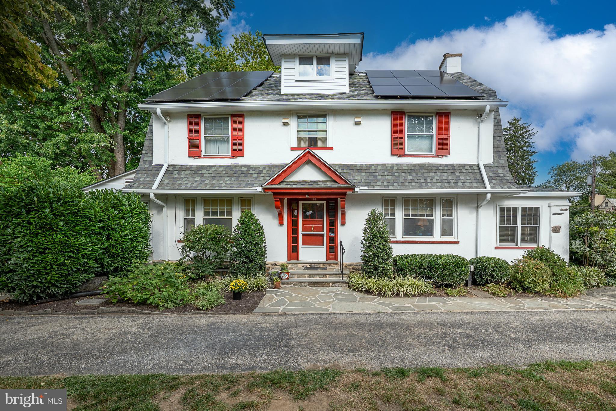 a front view of a house with yard and trees