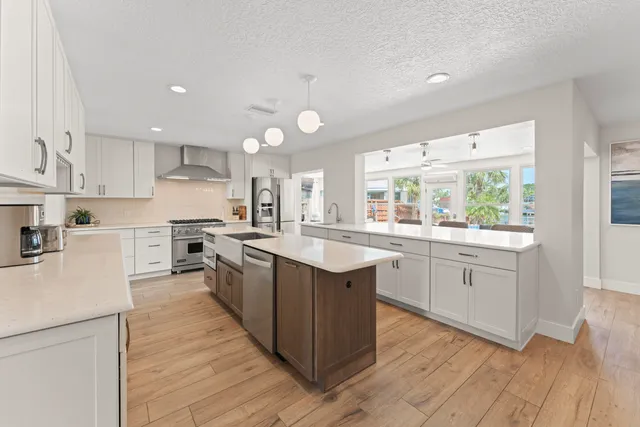 a large kitchen with stainless steel appliances lots of counter space and a sink