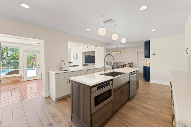 a kitchen with granite countertop a sink stainless steel appliances and cabinets