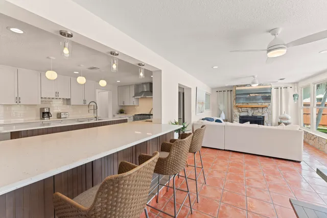 a large living room with stainless steel appliances granite countertop furniture and a wooden floor