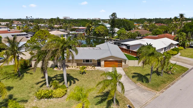 an aerial view of residential houses with outdoor space and trees