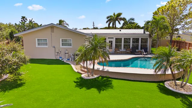 a view of a house with a yard and potted plants