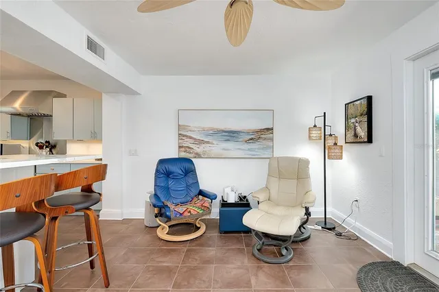 a view of a patio with table and chairs potted plants with floor to ceiling window