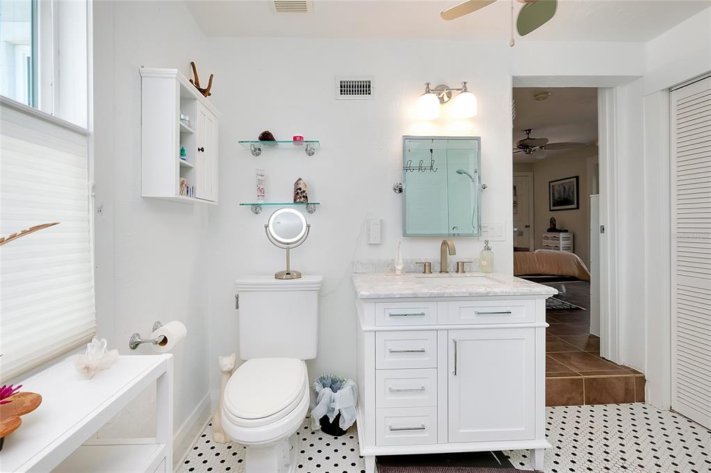 223 Palmetto Road West Nokomis, FL 34275 - Photo 37 of 100 a bathroom with a granite countertop toilet a sink and a mirror